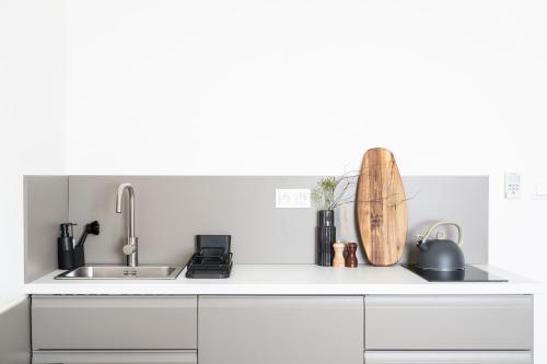 a white kitchen with a sink and a counter at Prague City Golf Apartments in Prague