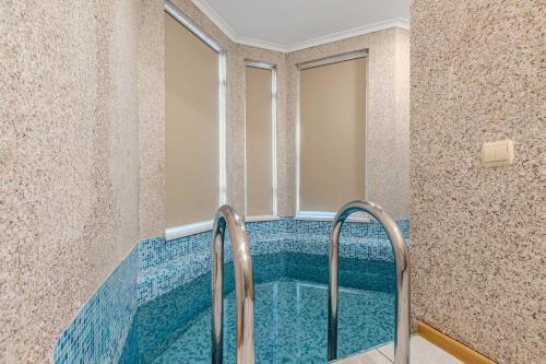 a swimming pool in a bathroom with blue tile at Bukovel Hotel in Bukovel