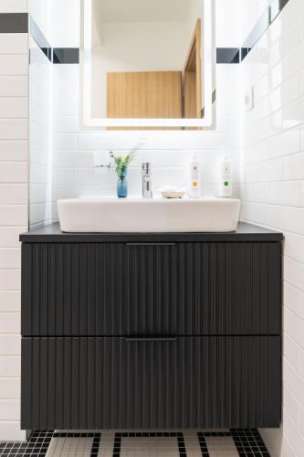 a bathroom with a black cabinet with a sink at Prague City Golf Apartments in Prague