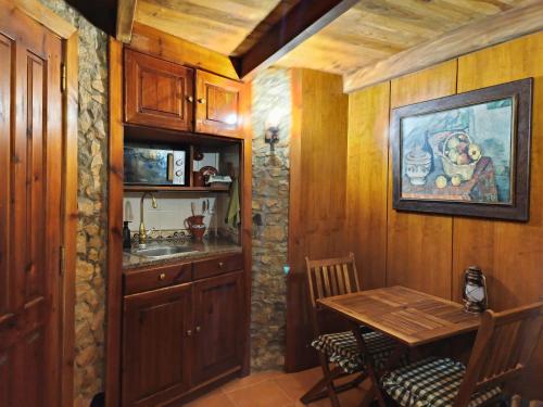 a kitchen with a table and a sink in a room at Moinhos do Alecrim in Penacova