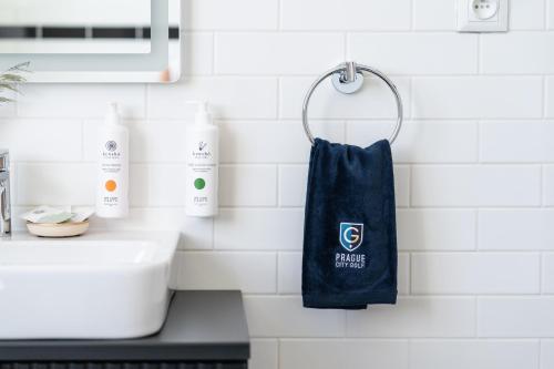 a blue towel hanging on a wall next to a sink at Prague City Golf Apartments in Prague