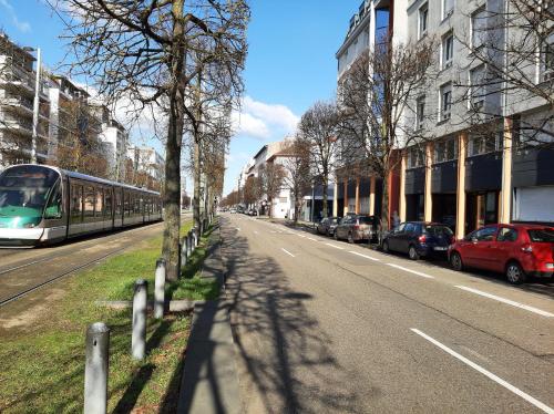 un train dans une rue de la ville avec des voitures garées dans l'établissement Riadh, à Strasbourg