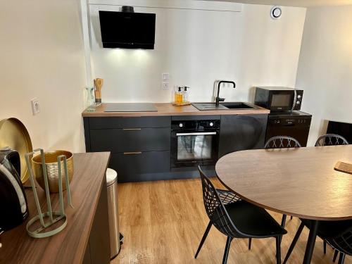 - une cuisine avec une table, une cuisinière et un évier dans l'établissement Le Duplex - Gare - 4 Personnes, au Mans