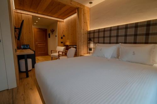 a bedroom with a large white bed in a room at Hotel San Lorenzo in Bormio