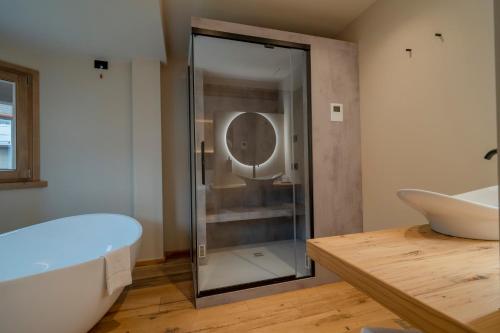 a glass shower in a bathroom with a tub at Hotel San Lorenzo in Bormio