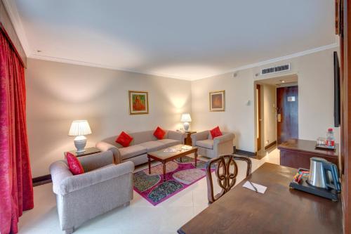 a living room with a couch and a table at Pearl Continental Hotel, Rawalpindi in Rawalpindi