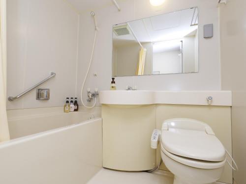 a bathroom with a toilet and a sink and a mirror at 多武峰観光ホテル in Sakurai
