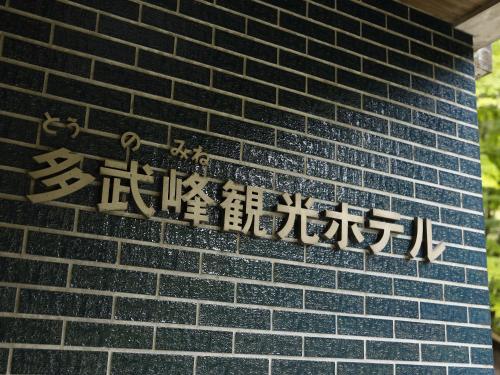 a sign on the side of a brick wall at 多武峰観光ホテル in Sakurai