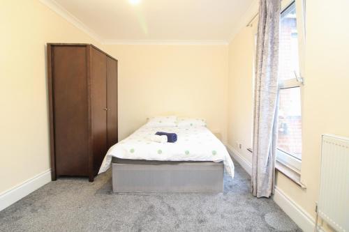 a bedroom with a bed and a cabinet and a window at Centrally located double room in Southampton