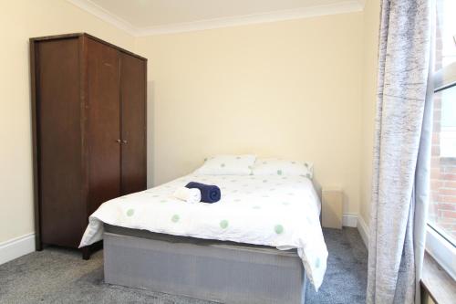 a small bedroom with a bed and a wooden cabinet at Centrally located double room in Southampton