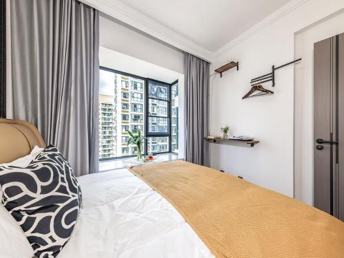 a bedroom with a bed and a large window at Annie 2704-only 260 metres from Metro Line 2 Exit C of BeiChun in Kunming