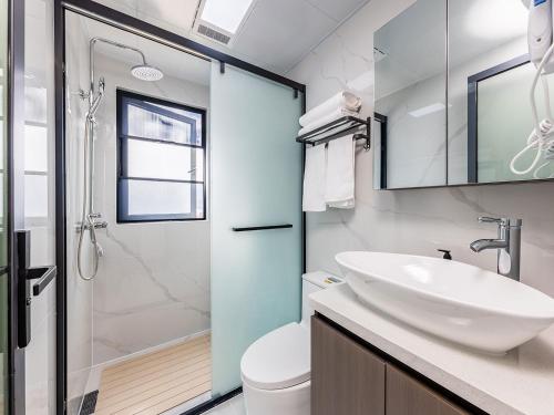a bathroom with a sink and a toilet and a shower at Annie 2704-only 260 metres from Metro Line 2 Exit C of BeiChun in Kunming