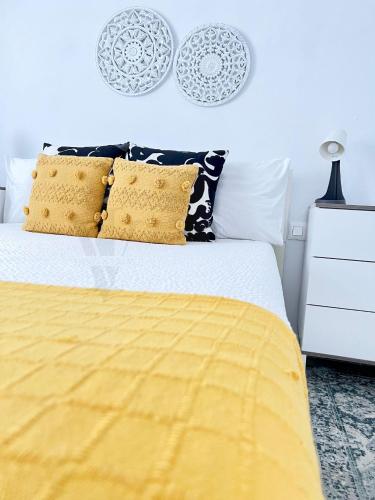 a bedroom with a bed with a yellow comforter and pillows at Imperial Villas I Mar y Playa in Puerto del Carmen