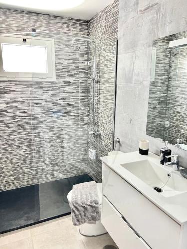 a bathroom with a white sink and a shower at Imperial Villas I Mar y Playa in Puerto del Carmen