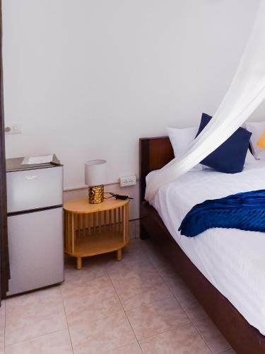 a bedroom with a bed and a table with a night stand at Burni Houses in Klong Prao Beach