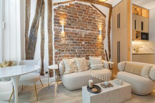un salon avec un canapé et un mur de briques dans l'établissement Central historic loft by architect, near Louvre, à Paris