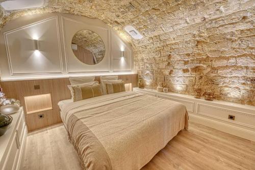 une chambre avec un grand lit et un mur en pierre dans l'établissement Central historic loft by architect, near Louvre, à Paris