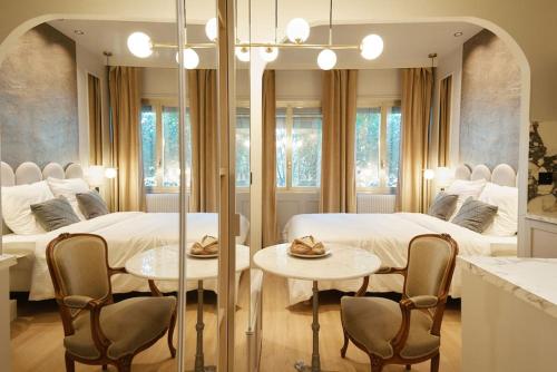 - une chambre avec 2 lits et 2 tables et chaises dans l'établissement Calacatta Room - Duke Housing, à Paris