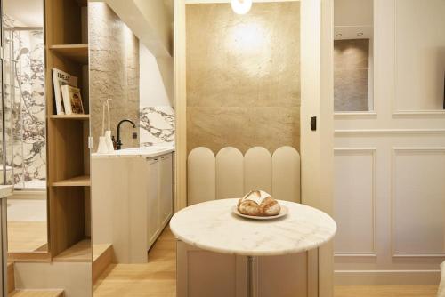 une cuisine avec une table avec un bol dessus dans l'établissement Calacatta Room - Duke Housing, à Paris
