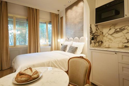 - une chambre avec 2 lits et une table avec un chapeau dans l'établissement Calacatta Room - Duke Housing, à Paris