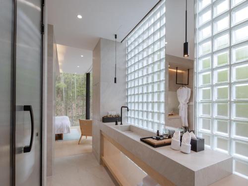 un bagno con un lavandino e una grande finestra di Moganshan Linqiguyin Hotel a Fanjiawu