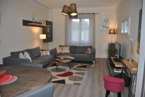 ein Wohnzimmer mit einem Sofa und einem Tisch in der Unterkunft Le Calme au Centre Ville à 10 minutes à pied de la Croisette et des plages in Cannes