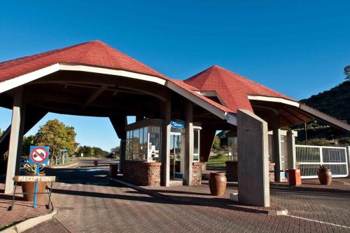 un bâtiment avec un toit rouge dans une rue dans l'établissement Gariep, A Forever Resort, à Gariepdam