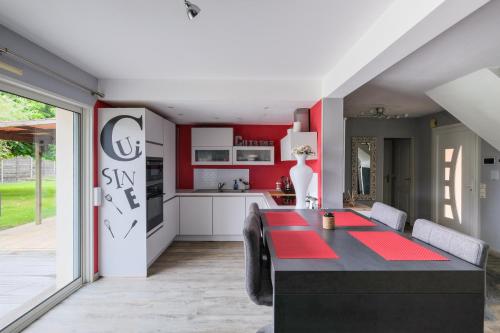 une cuisine et une salle à manger avec une table et des chaises dans l'établissement Le Logis de La Baule - Maison climatisée piscine, à La Baule