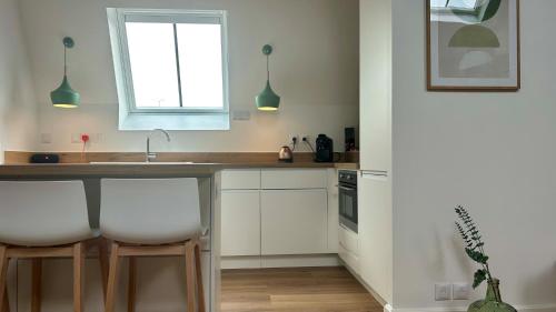 une cuisine avec des armoires blanches et un évier dans l'établissement La suite Nature jacuzzi au cœur du château de Boissettes, à Boissettes