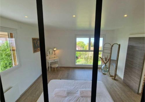 une chambre blanche avec un lit et une fenêtre dans l'établissement Les Bois du Lac, à Neuvecelle