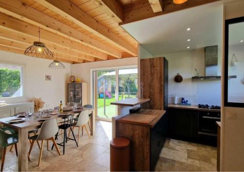 une cuisine et une salle à manger avec une table et des chaises dans l'établissement Les Bois du Lac, à Neuvecelle