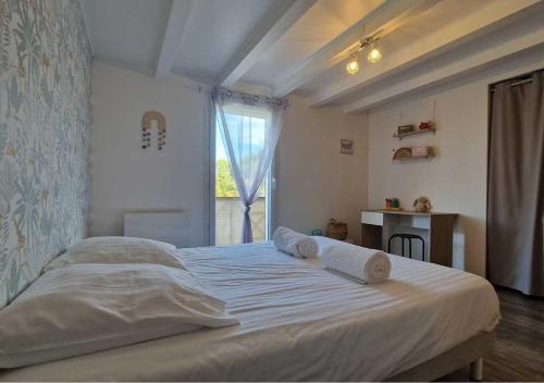 une chambre avec un grand lit blanc avec une fenêtre dans l'établissement Les Bois du Lac, à Neuvecelle