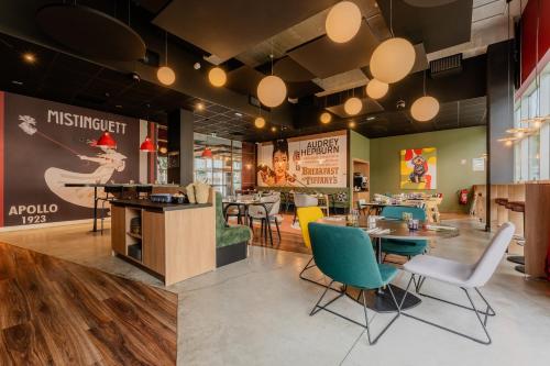 a restaurant with chairs and tables in a room at ibis Styles Lens Centre Gare in Lens