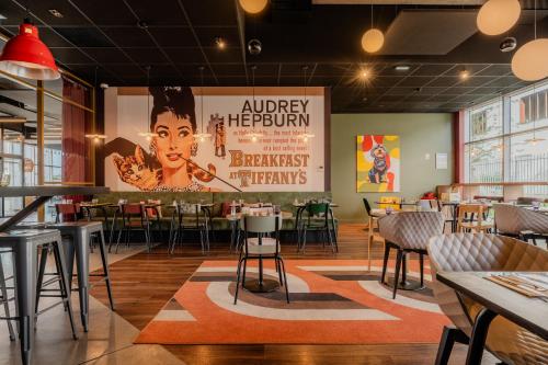 a restaurant with a large poster on the wall at ibis Styles Lens Centre Gare in Lens