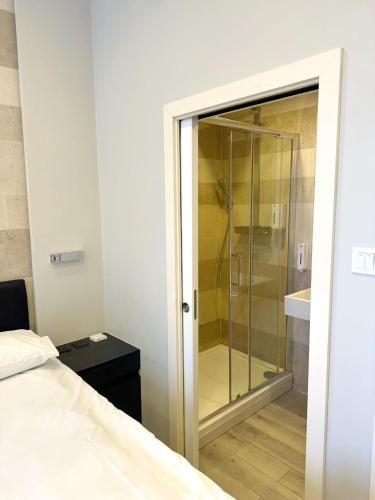 a bathroom with a glass shower and a bed at 95 Studios in London