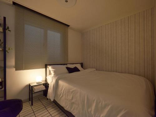 a bedroom with a white bed and a window at joyfulstay in Seoul