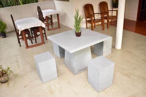 una mesa blanca y sillas con una maceta. en Subahas Backpacker, en Galle