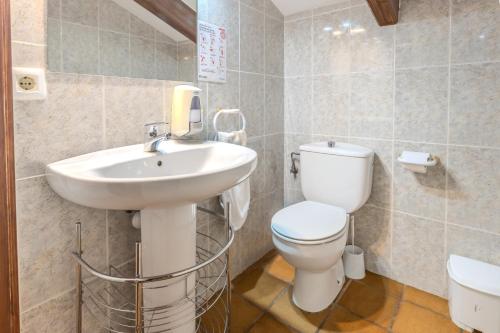 a bathroom with a white sink and a toilet at Can Mestrehumà in Bas