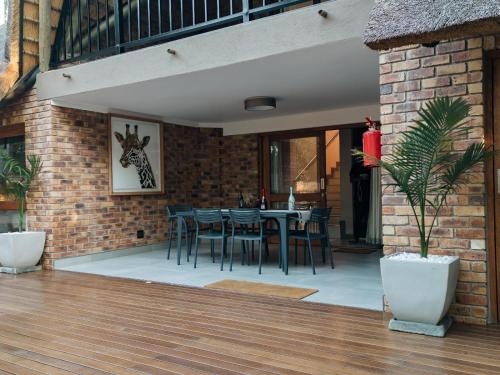 a patio with a table and chairs on a brick wall at DUBE SAFARI LODGE at Kruger Park Lodge 505 in Hazyview