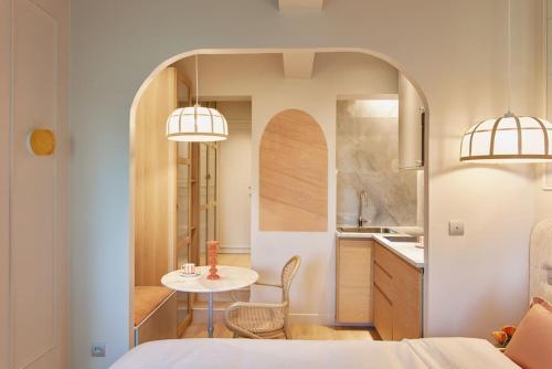 une chambre avec une table et une cuisine avec deux lumières dans l'établissement Hermes Room - Duke Housing, à Paris