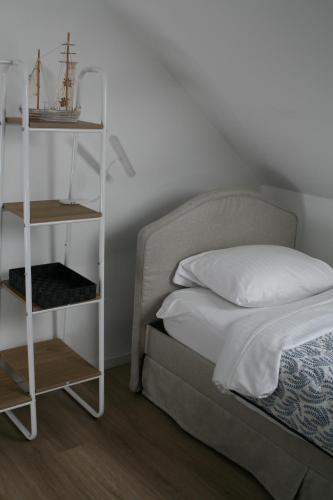 a bedroom with a bed with a white shelf next to it at Seehafen Hostel in Hamburg