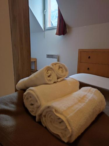 two towels are stacked on a bed in a bedroom at Résidence Val de Roland in Luz-Saint-Sauveur