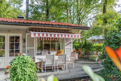 a house with a table and chairs on a deck at Chalet 2Relax in Zutendaal