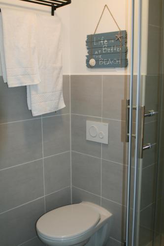 a bathroom with a toilet and a shower with towels at Seehafen Hostel in Hamburg