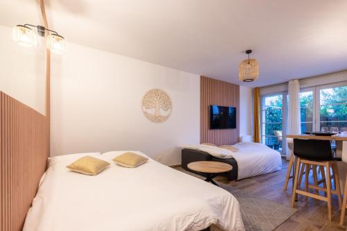 une chambre d'hôtel avec deux lits et un bureau dans l'établissement Disneyland-Charmant appartement 8 personnes-Terrasse-Gare-Parking, à Montévrain