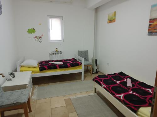 a bedroom with two beds and a table and a window at Mountain Relax Vlašić in Vlasic