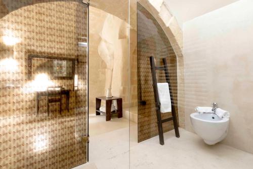 a bathroom with a shower and a toilet and a sink at Sant'Angelo, Matera - Small Luxury Hotels in Matera