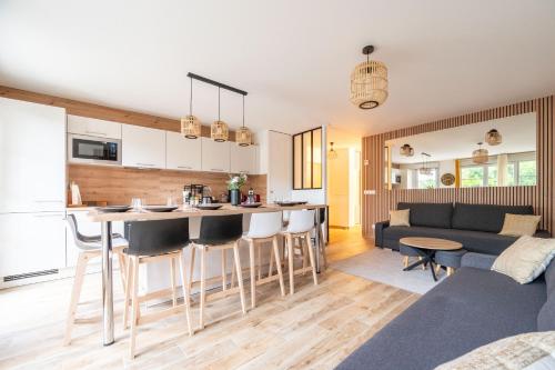 une cuisine et un salon avec un canapé et une table dans l'établissement Disneyland-Charmant appartement 8 personnes-Terrasse-Gare-Parking, à Montévrain