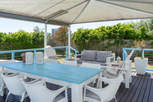 a blue table and white chairs on a deck at Blue Star Villa in Tergniet