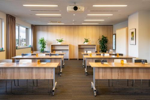a conference room with tables and chairs and plants at INNSiDE by Meliá Aachen in Aachen
